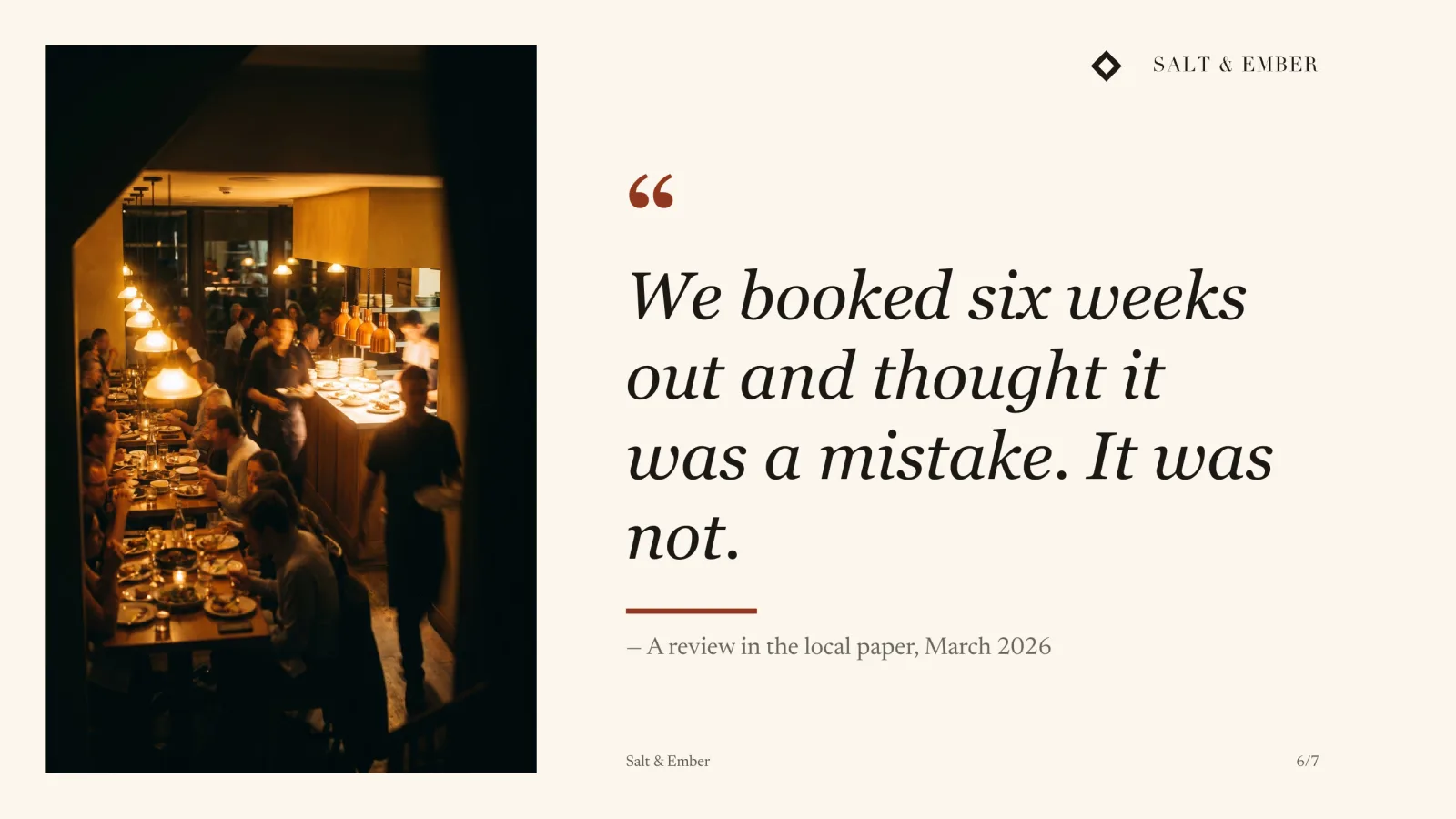 A quote from a local paper review set beside a photograph of the restaurant full at service: warm lamplight, every table taken, plates going out.